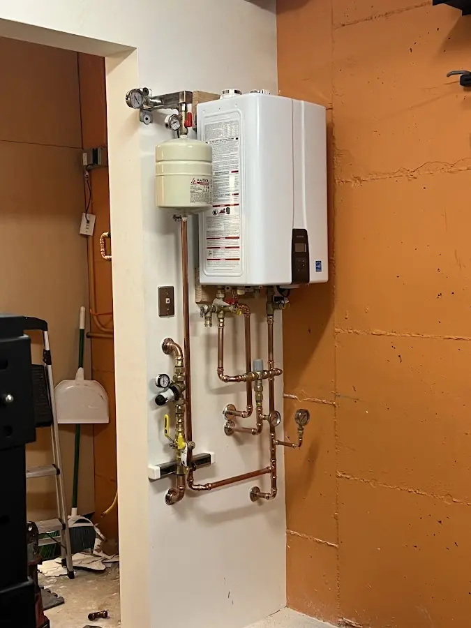 Plumbing technician inspecting water heater connections in Rio Bravo